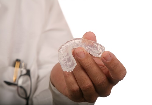 Dentist holding a mouthguard in his hand