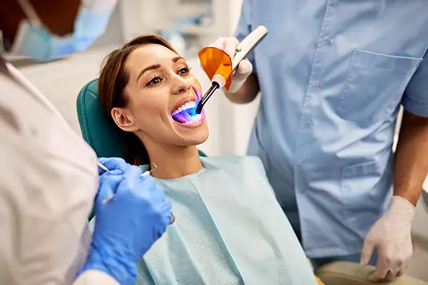 Woman getting dental sealant treatment.