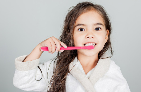 Young girl brushing her teeth at Cascade Dental in Medford, OR